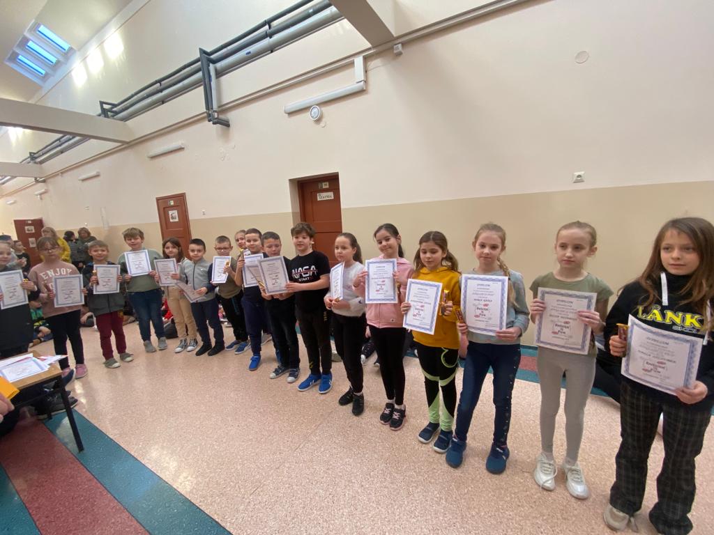 Na zdjęciu uczniowie klas drugich i trzecich, którzy brali udział w konkursie z języka angielskiego, uczniowie w rękach trzymają dyplom. 