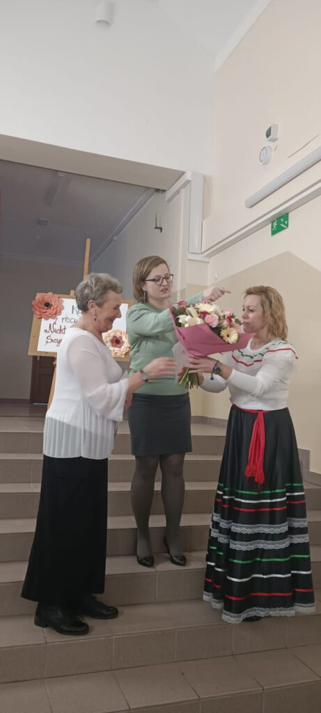 Na zdjęciu od prawej dyrektor szkoły wręcza kwiaty laureatce w kategorii dorośli. Na środku przewodnicząca rady rodziców. Po lewej pani Katarzyna Rogalska laureatka konkursu.