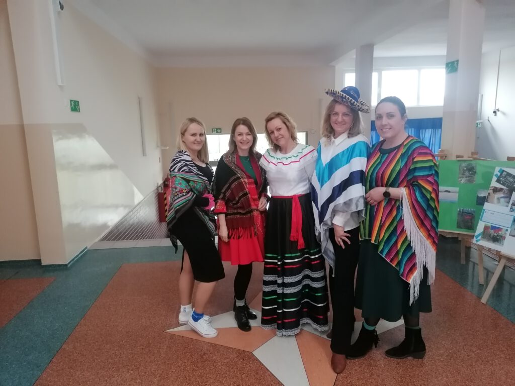 Na zdjęciu stoi pięć nauczycielek, każda   z nich ma na sobie element stroju/ubioru w chilijskich kolorach. 