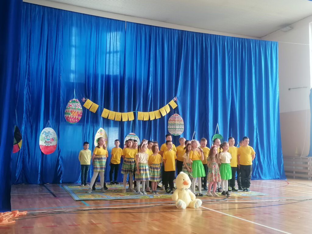 Apel Wielkanocny- dekoracja sali. Na zdjęciu widać dzieci ubrane żółte koszulki 