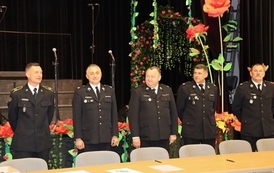 Powiatowe eliminacje Ogólnopolskiego  Turnieju Wiedzy Pożarniczej „Młodzież Zapobiega Pożarom”. Na  zdjęciu widać czterech panów stojących  na auli, ubrani są w odświętne mundury strażackie., 