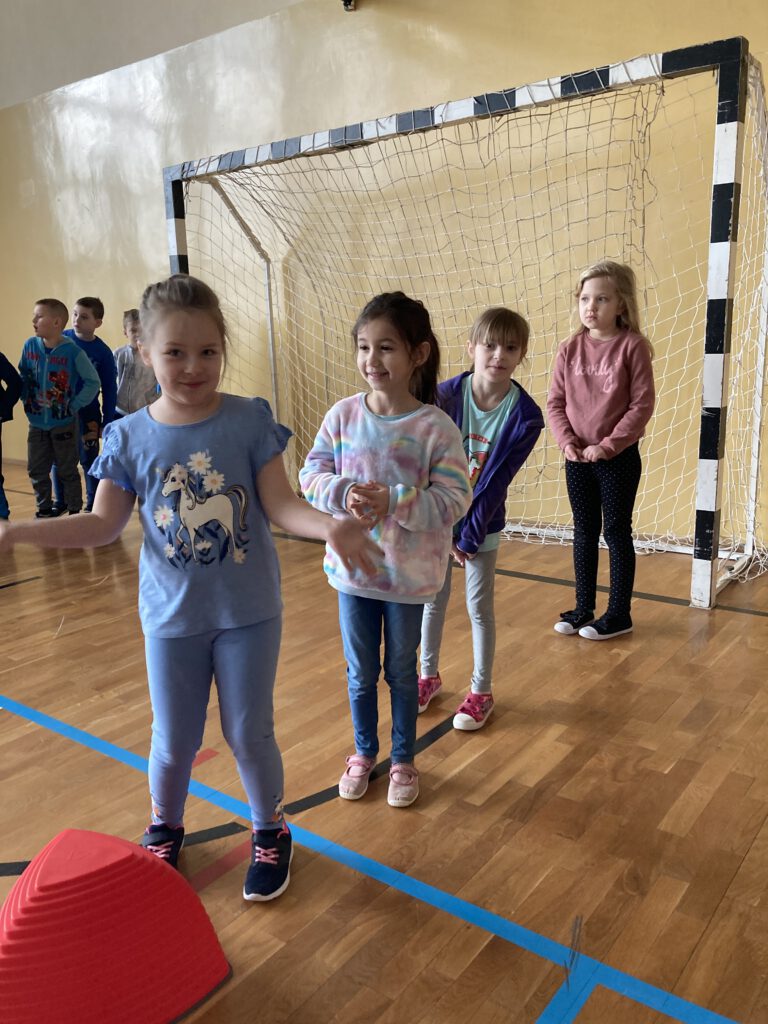Światowy Dzień Świadomości Autyzmu- Niebieskie Igrzyska- dziewczynki z klasy 1b w oczekiwaniu na pierwsze ćwiczenia sportowe. 