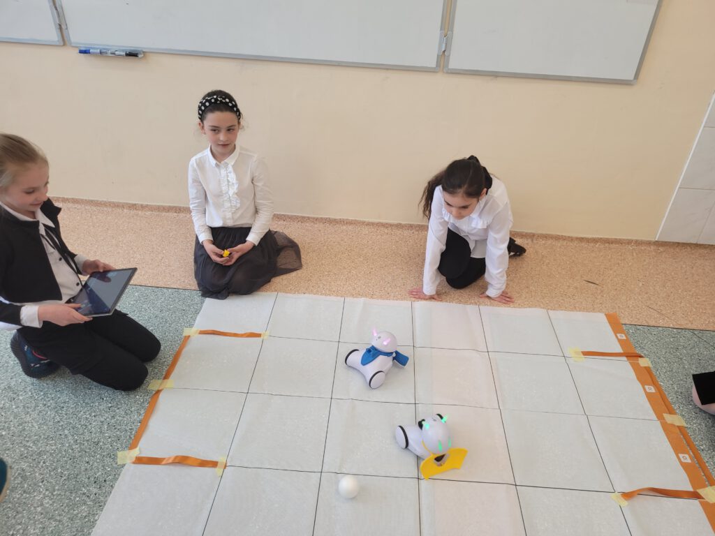 Zajęcia w ramach projektu "Laboratoria Przyszłości". Uczniowie klasy 3a grają w piłkę robotami.