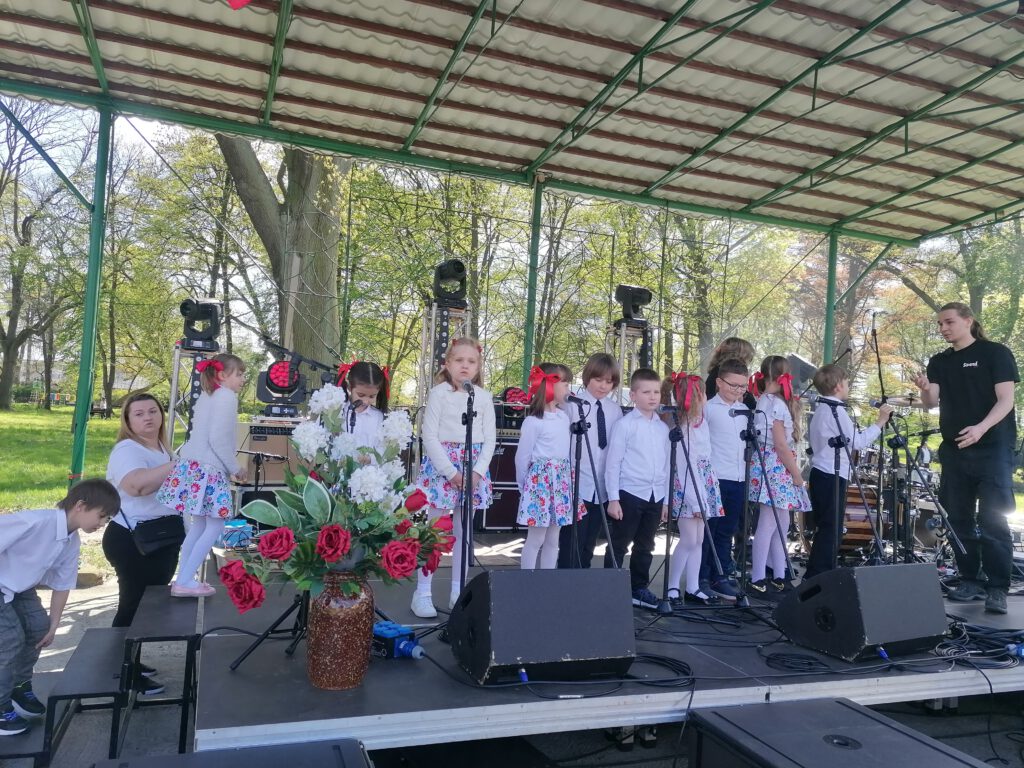 Obchody Majówki 2023- występ uczniów klasy I b. Uczniowie stoją na scenie i przygotowują się do śpiewania piosenki. 