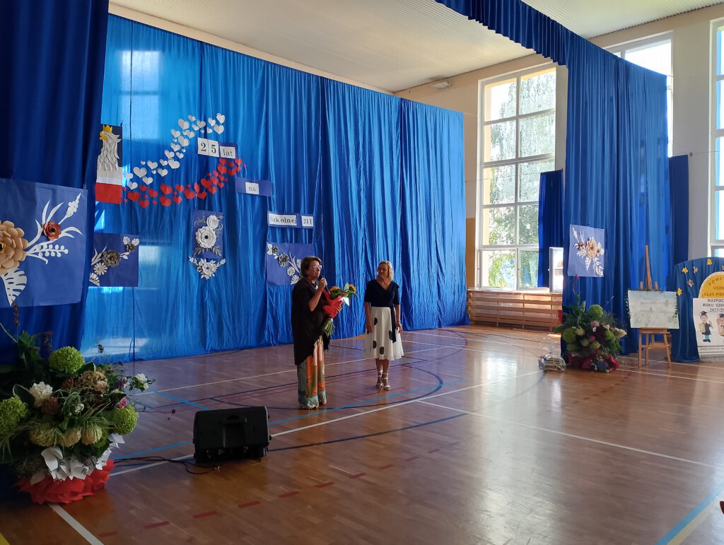 Inauguracja nowego roku szkolnego 2023/2024 i Jubileusz 25-lecia szkoły. Na zdjęciu była Pani Dyrektor Elżbieta Urbanowicz-Przysiężna składa obecnej Pani Dyrektor Grażynie Chudej gratulacje z okazji jubileuszu.  