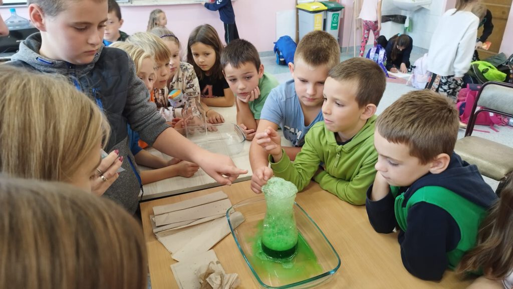 Luźne lekcje z naukowcami- eksperyment wulkan. Uczniowie świetlicy szkolnej obserwują eksperyment "wulkan".