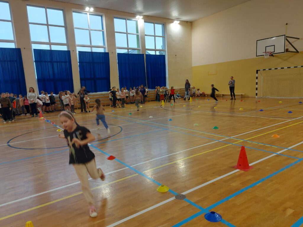 Na zdjęciu uczniowie klas 1-3  biorący udział w wyścigach na sali gimnastycznej.  