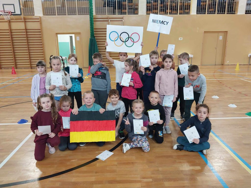 Ceremonia Otwarcia Igrzysk dla Dzieci -Projekt Akiliada.  na zdjęciu uczniowie klasy 1 b z flagą Niemiec. 