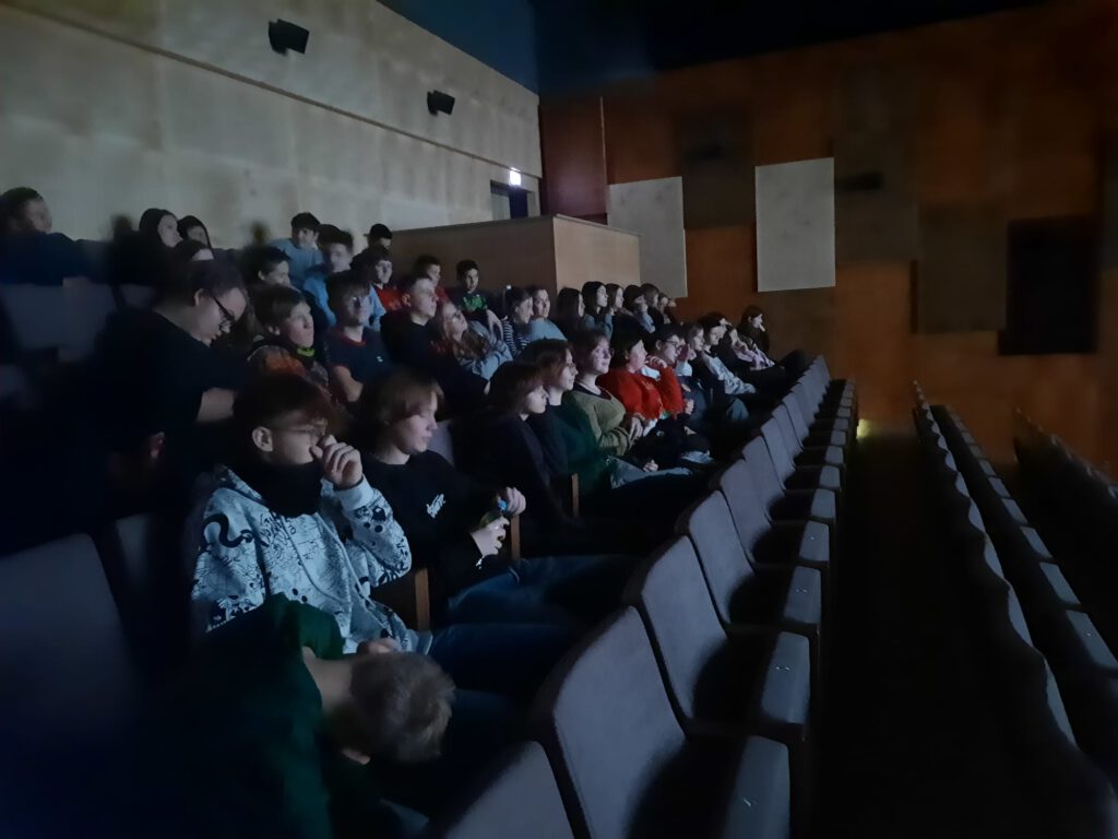 Na zdjęciu grupa uczniów w sali kinowej.
