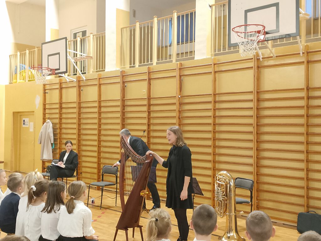 Koncert filharmonii- harfa i tuba. Na zdjęciu pani opowiada uczniom o harfie. 