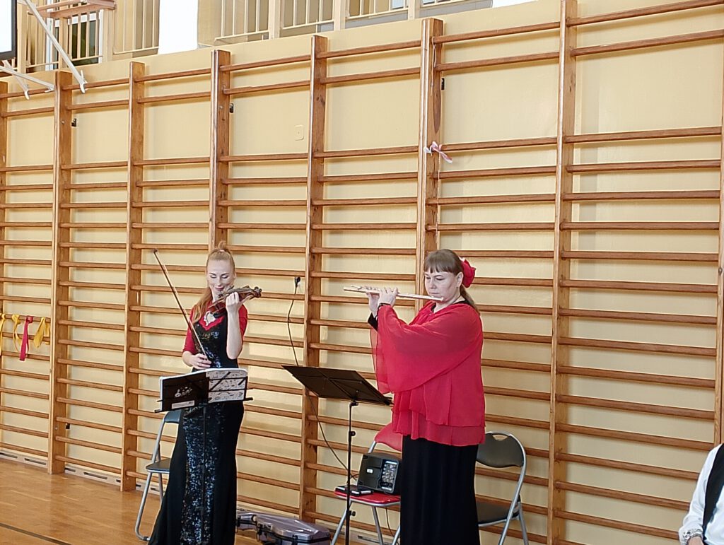 Koncert filharmonii przygotowany przez Lubuskie Biuro Koncertowe. Na zdjęciu dwie panie: jedna gra na skrzypcach, druga na flecie. 
