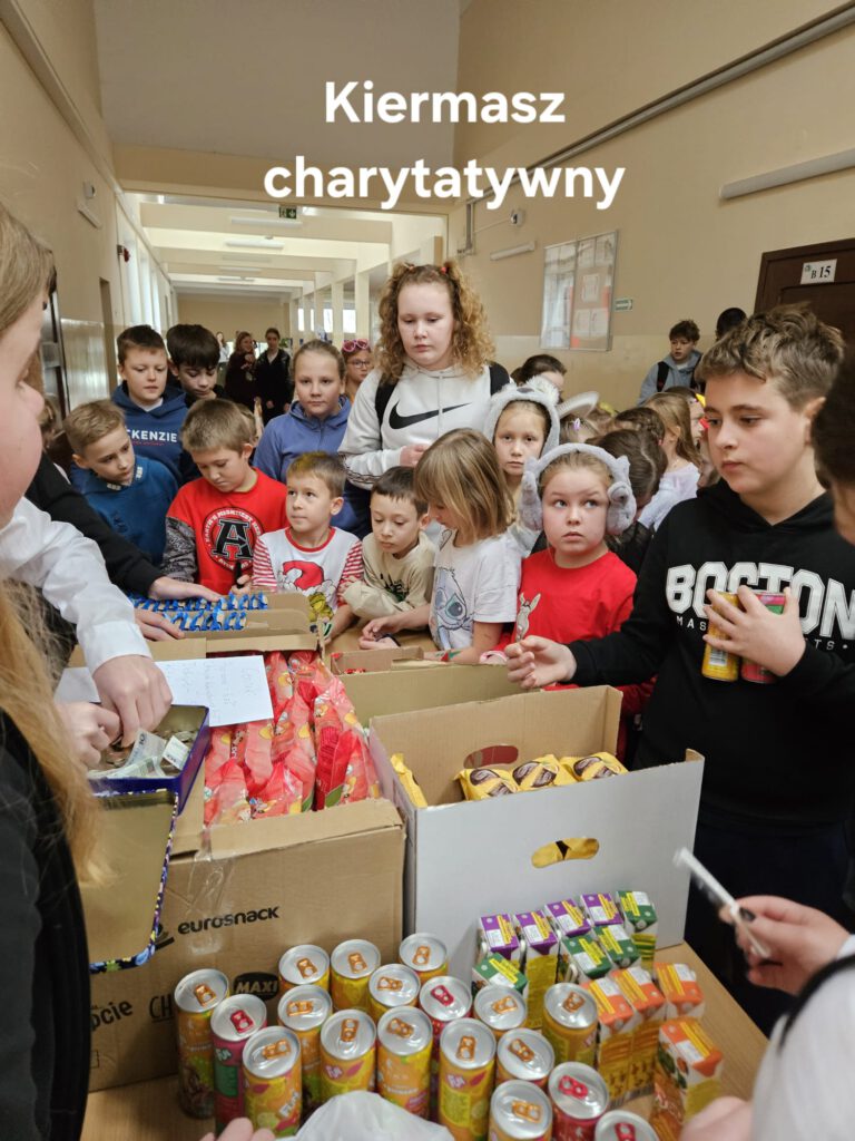 Akcja- świąteczna pomoc dla potrzebujących. na zdjęciu uczniowie kupujący smakołyki na kiermaszu charytatywnym. 