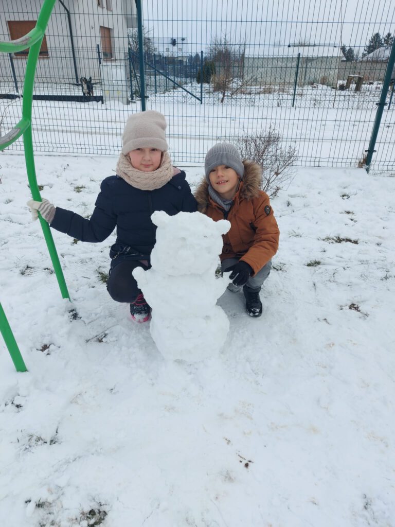 Moving Schools Challenger – przegląd stycznia. Na zdjęciu dwoje uczniów lepi misia ze śniegu. 