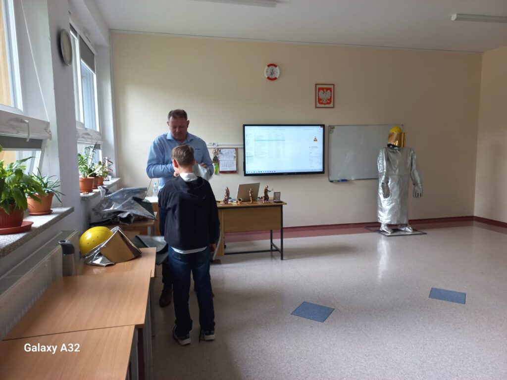 Pracownik KGHM (hutnik) przedstawiający prezentację dotycząca budowy huty, pracy na różnych stanowiskach oraz wytworzonych w hucie surowców.