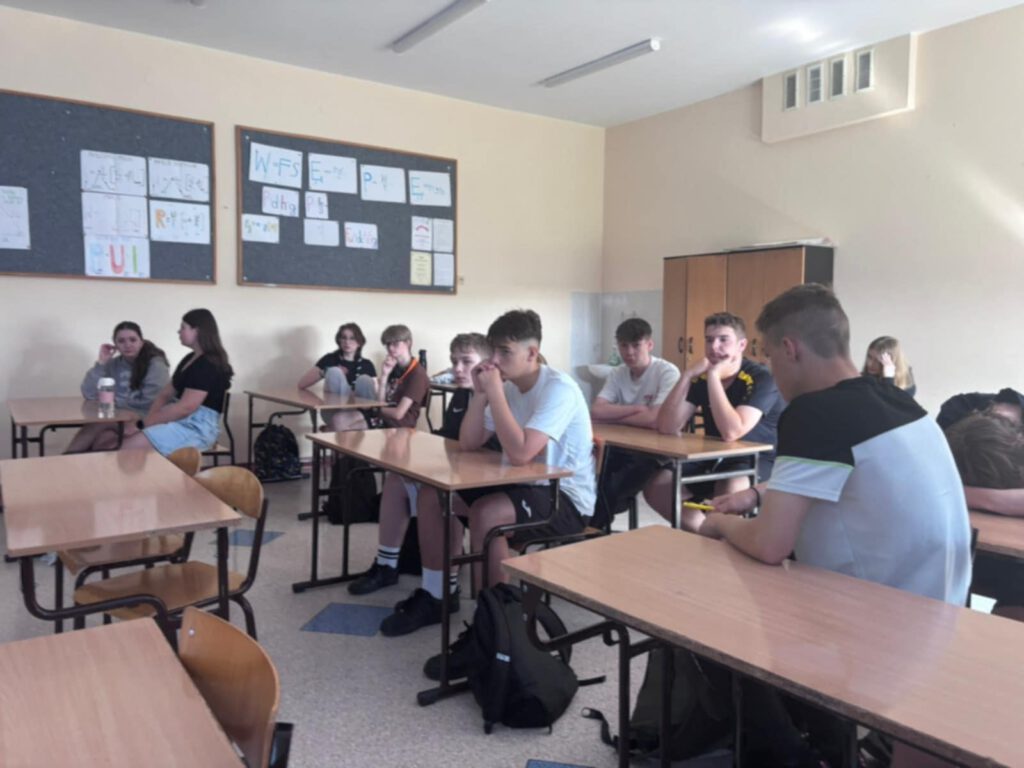 Warsztaty z doradztwa zawodowego. Na zdjęciu uczniowie klas ósmych siedzą w ławkach i słuchają wykłady na temat wyboru zawodu. 