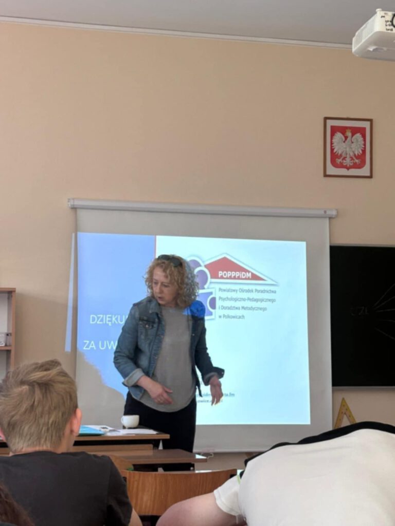 Warsztaty z doradztwa zawodowego. Na zdjęciu pani z poradni prezentuje uczniom na wyświetlaczu prezentację. 