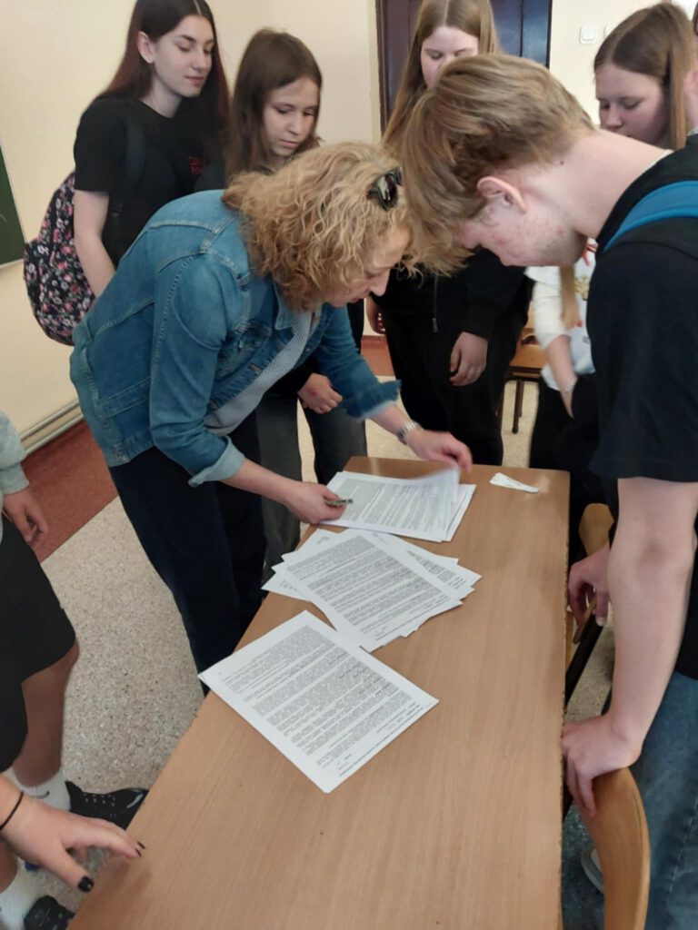 Warsztaty z doradztwa zawodowego. Na zdjęciu uczniowie klas ósmych stoją wokół pani z poradni, która prowadziła warsztaty. 