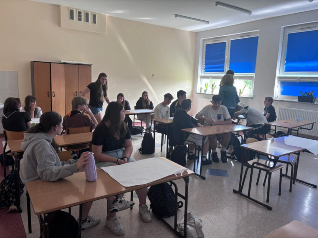 Warsztaty z doradztwa zawodowego. Na zdjęciu uczniowie klas ósmych siedzą w ławkach i słuchają wykłady na temat wyboru zawodu. 