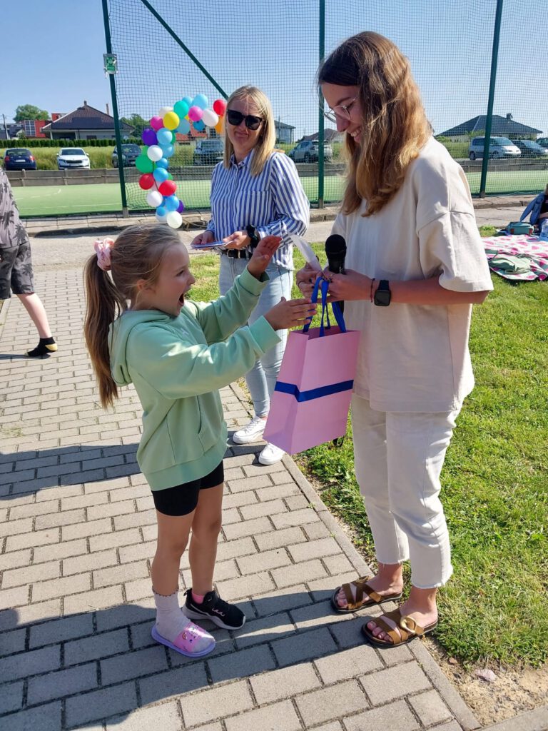 Rozstrzygnięcie akcji „Zagadka Dnia”. Wychowawczyni świetlicy wręcza nagrodę II Wicemistrzyni Zagadek w kategorii klas 1-3.
