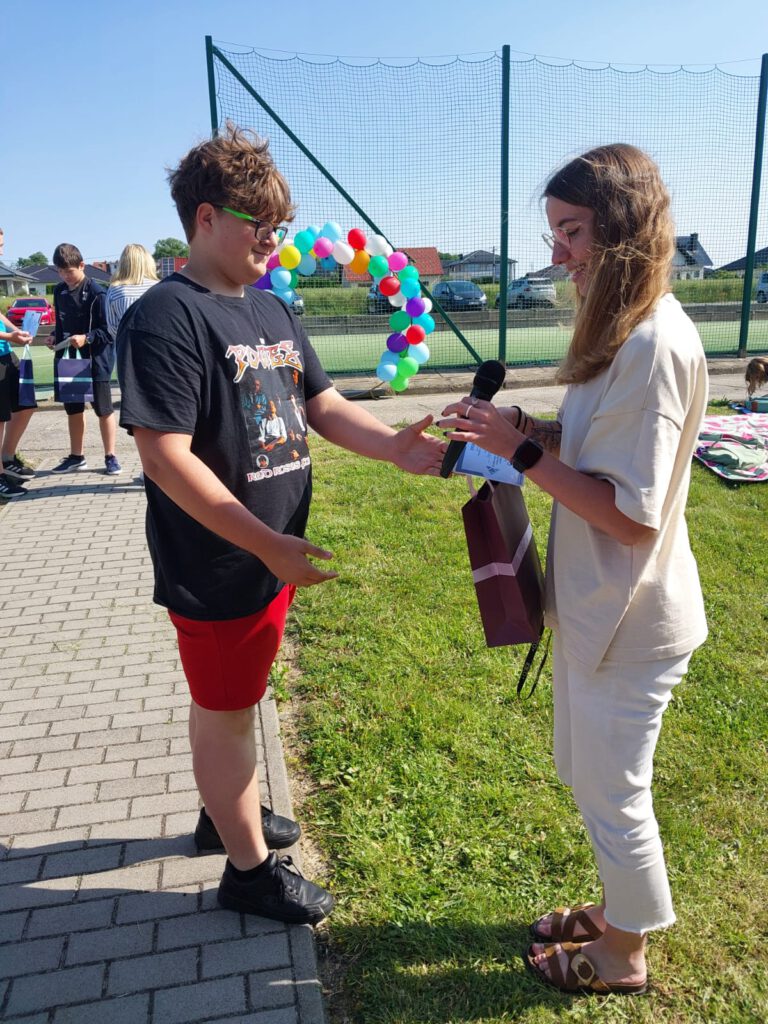 Rozstrzygnięcie akcji „Zagadka Dnia”. Wychowawczyni świetlicy wręcza nagrodę Mistrzowi Zagadek w kategorii klas 4-8.