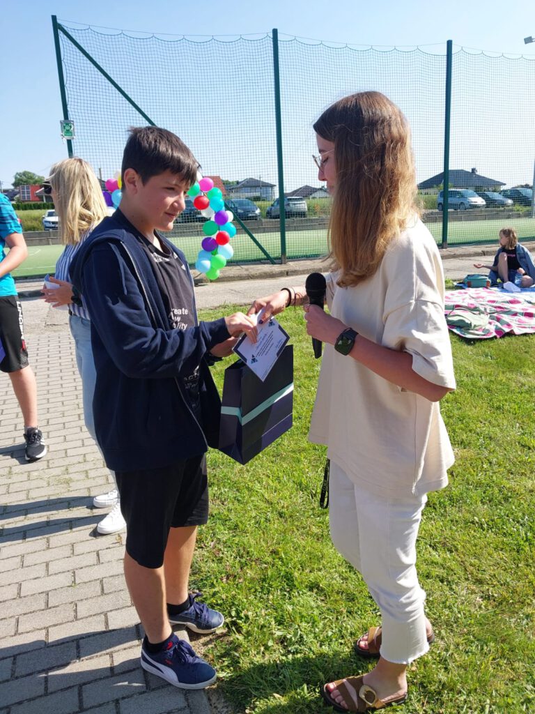 Rozstrzygnięcie akcji „Zagadka Dnia”. Wychowawczyni świetlicy wręcza nagrodę I Wicemistrzowi Zagadek w kategorii klas 4-8.