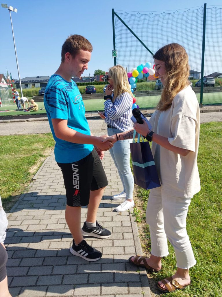 Rozstrzygnięcie akcji „Zagadka Dnia”. Wychowawczyni świetlicy wręcza nagrodę II Wicemistrzowi Zagadek w kategorii klas 4-8.