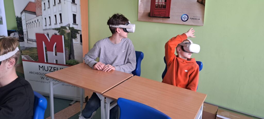 Spotkania edukacyjno-interaktywne "W czasach pierwszych Piastów" z wykorzystaniem technologii VR. Na zdjęciu dwóch chłopców z założonymi okularami VR.