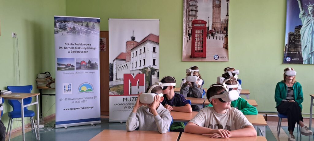 Spotkania edukacyjno-interaktywne "W czasach pierwszych Piastów" z wykorzystaniem technologii VR. Na zdjęciu uczniowie klasy 5b z okularami VR biorą udział interaktywnej lekcji historii.