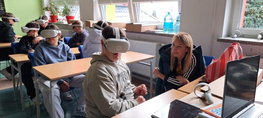 Spotkania edukacyjno-interaktywne "W czasach pierwszych Piastów" z wykorzystaniem technologii VR. Na zdjęciu uczniowie klasy 8a z okularami VR biorą udział w interaktywnym pokazie historii.