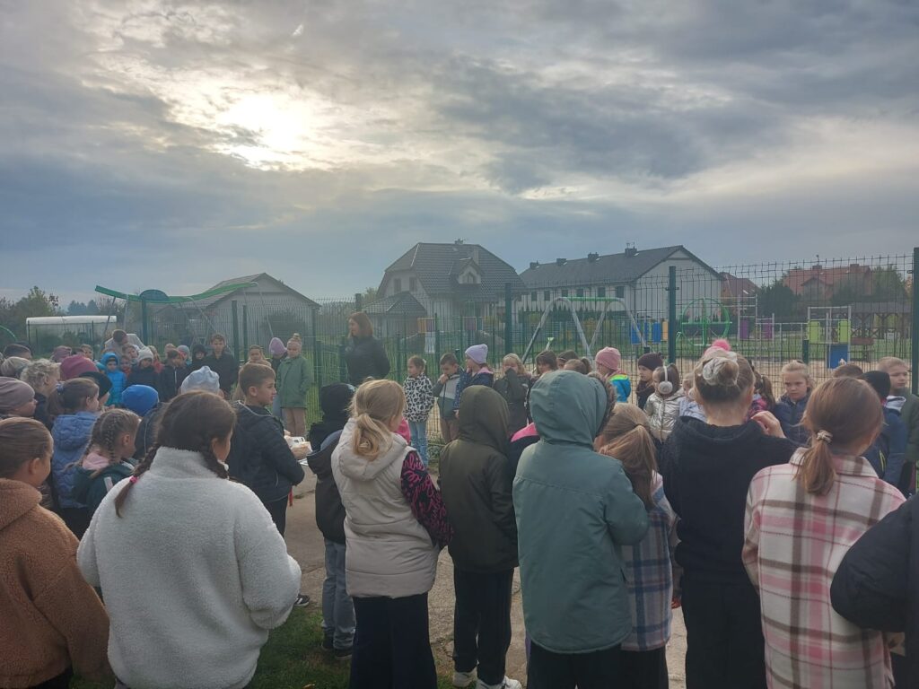 Klasy I- III stoją na dworze wokół stolika z chlebem i słuchaj istotnych wiadomości o chlebie.