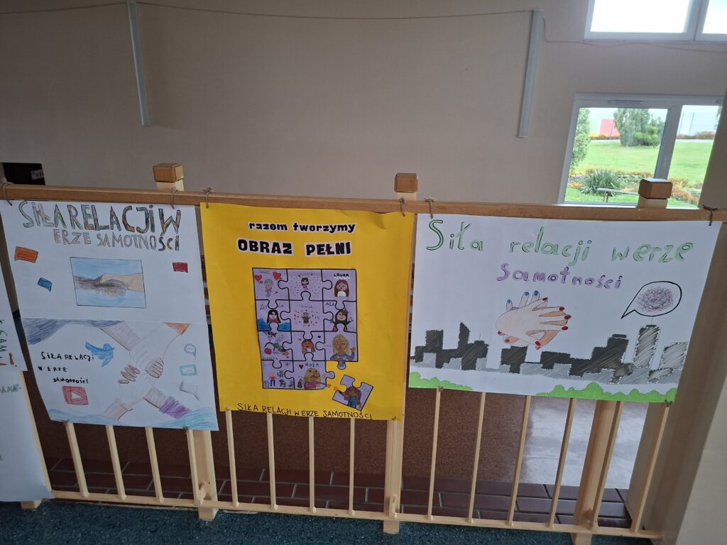 Przedstawia puzzle z obrazkami na których namalowane są osoby z klasy. Jeden puzzle jest oderwany.