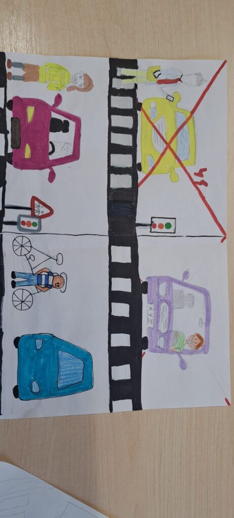 Odblaskowa szkoła 2025- komiksy uczniów. Na zdjęciu komiksy wykonane ręcznie prze uczniów w formie obrazkowej na temat bezpieczeństwa w ruchu drogowym, przy przechodzeniu przez jednię i stosowania zasad ruchu drogowego. 