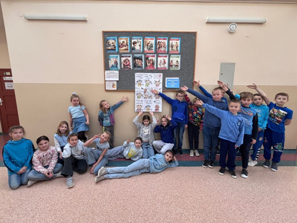 Światowy Dzień Praw Dziecka. Na zdjęciu znajduje się grupa dzieci z klasy 3a wraz z wychowawczynią ubranych w niebieskie koszulki, siedzących w kręgu podczas lekcji wychowawczej na temat „Światowy Dzień Praw Dziecka”.  