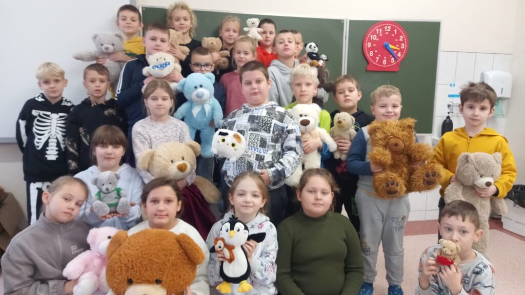 Światowy Dzień Pluszowego Misia. Dzieci z klas I- III pozują do zdjęcia ze swoimi pluszowymi misiami.