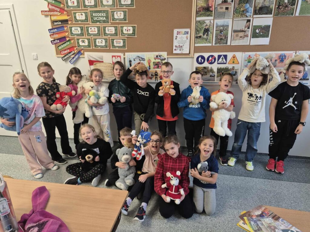 Światowy Dzień Pluszowego Misia. Dzieci z klas I- III pozują do zdjęcia ze swoimi pluszowymi misiami.
