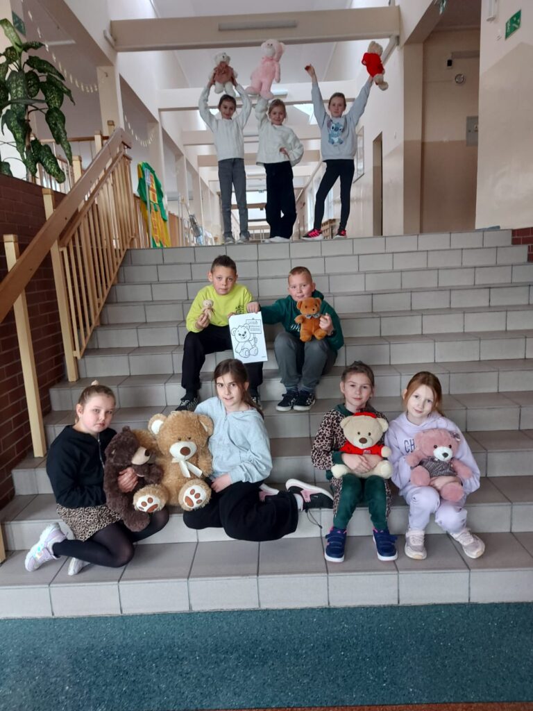 Światowy Dzień Pluszowego Misia. Dzieci z klas I- III pozują do zdjęcia ze swoimi pluszowymi misiami.