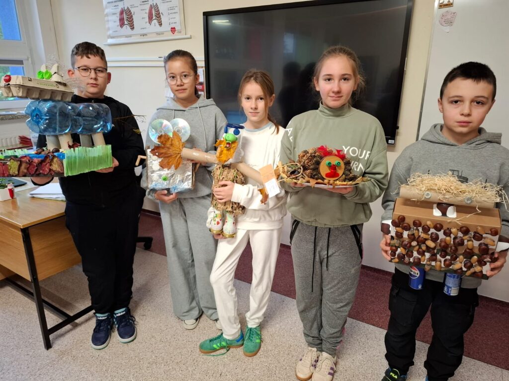 Na zdjęciu  uczniowie klasy 5b trzymający w rękach prace konkursowe. Wśród nich zwycięskie prace.