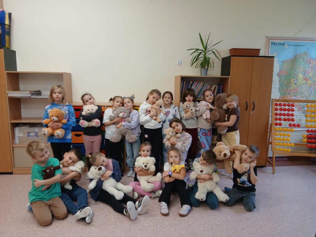 Światowy Dzień Pluszowego Misia. Dzieci z klas I- III pozują do zdjęcia ze swoimi pluszowymi misiami.
