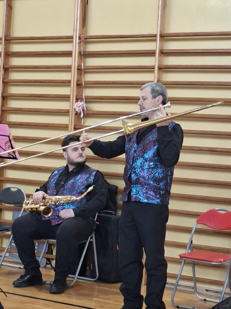 Koncert filharmonii. Na zdjęciu jeden z muzyków pokazuje jak zbudowany jest puzon. 