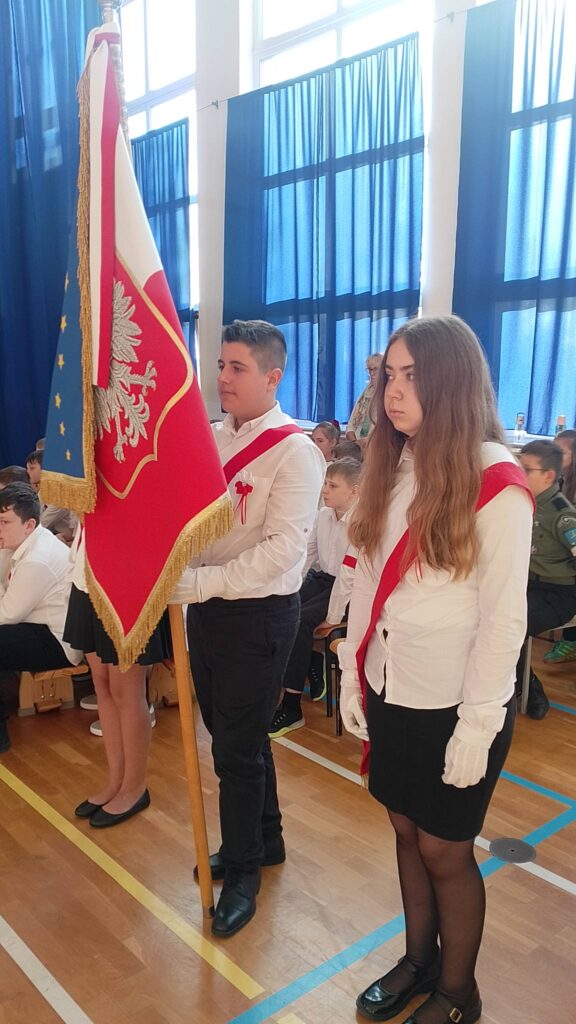 Apel z okazji Święta Niepodległości. Na zdjęciu uczniowie w poczcie sztandarowym, uczniowie ubrani na galowo.
