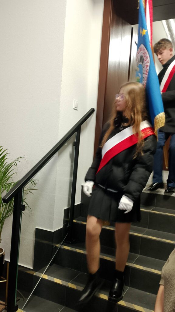 Udział sztandaru szkoły we Mszy Świętej w intencji Ojczyzny. Na zdjęciu poczet sztandarowy schodzi ze schodów. 
