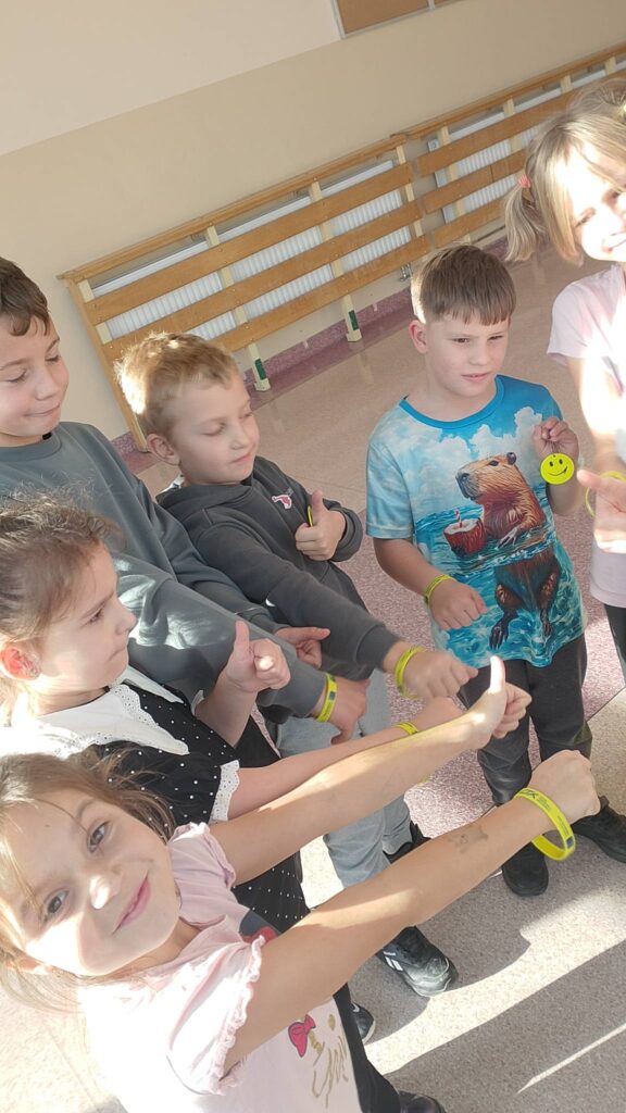 Odblaskowa Szkoła 2025- akcja rozdawania odblasków. Na zdjęciu najmłodsi uczniowie naszej szkoły prezentują ręce  z założonymi odblaskami. 
