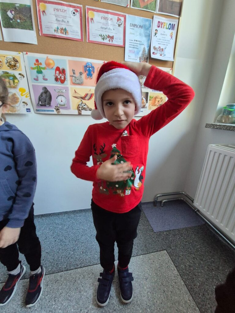 Integracyjny WF online - Tajemnica Świątecznej Fabryki. Na zdjęciu uczeń wykonuje ćwiczenia rękami według tego, co widzi na ekranie.