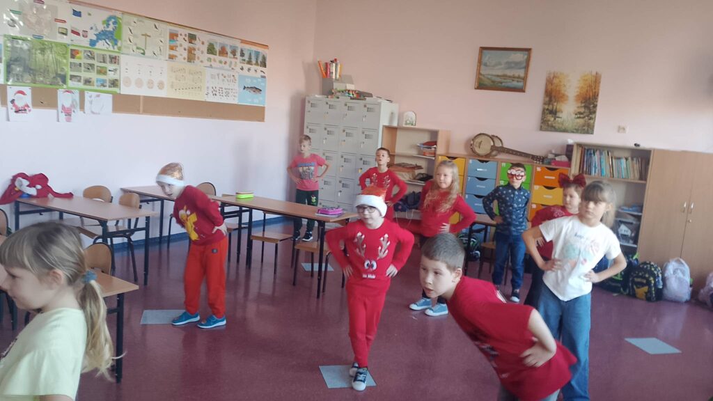 Integracyjny WF online - Tajemnica Świątecznej Fabryki. Na zdjęciu uczniowie wykonują skręty tułowiem według tego, co widzą na ekranie.