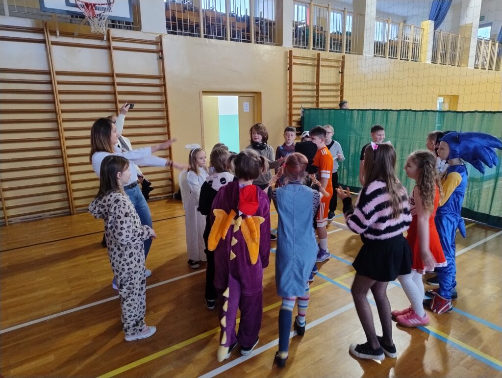 Uczniowie klasy 3a tańczą w kółku razem ze swoją wychowawczynią.