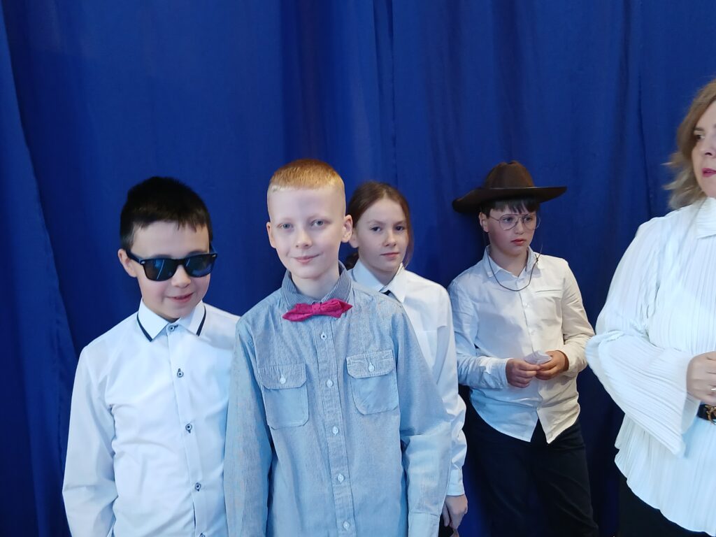 Dzień Kobiet. Na zdjęciu chlopcy z klasy piątej obrani w biale koszule czekają na występ.