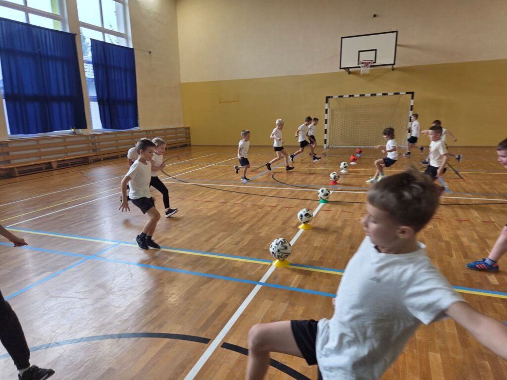 Program "Aktywna Szkoła do Kwadratu". Na zdjęciu uczniwoie ćwiczą triki z piłką nożną.