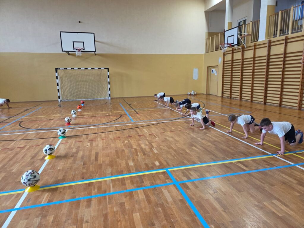 Program "Aktywna Szkoła do Kwadratu". Na zdjęciu uczniwoie ćwiczą triki z piłką nożną.