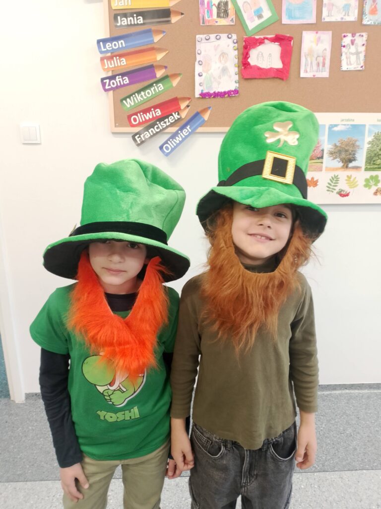 Obchody Dnia św. Patryka- patrona Irlandii. Na zdjęciu dwóch uczniów pozuje do zdjcia, na gowie mają zielone kapelusze i rude brody.