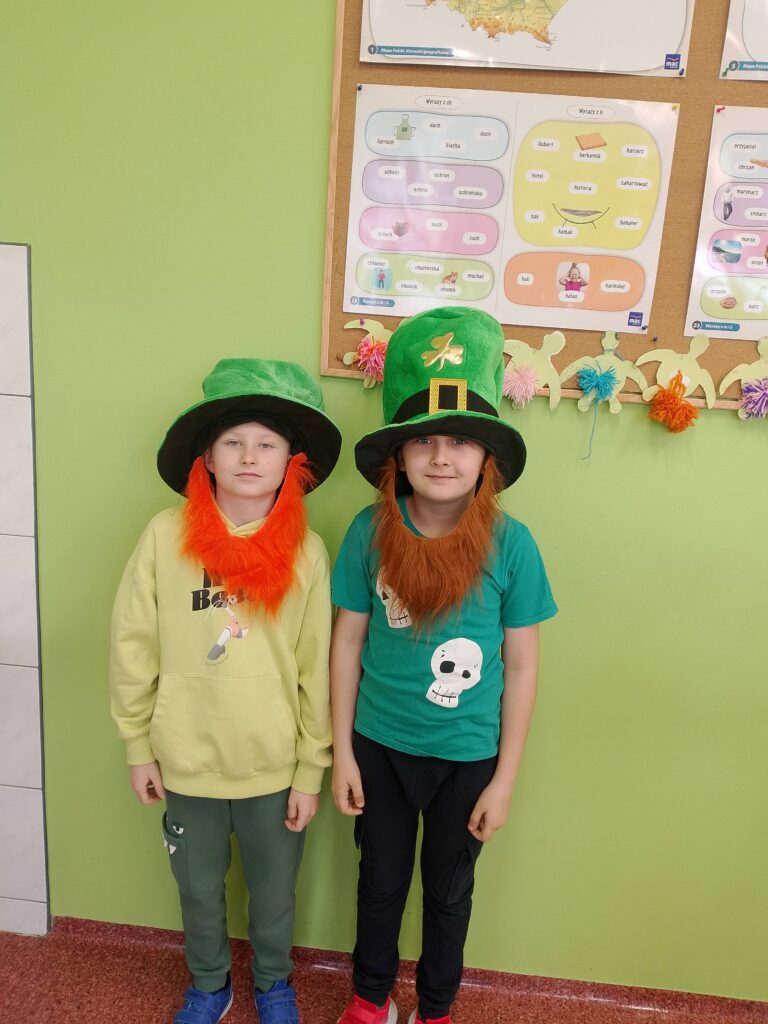 Obchody Dnia św. Patryka- patrona Irlandii. Na zdjęciu dwóch uczniów pozuje do zdjcia, na głowie mają zielone kapelusze i rude brody.